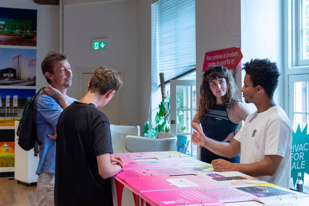 Bezoekers in gesprek met Waagmedewerkers bij de Fix Your Phone Shop