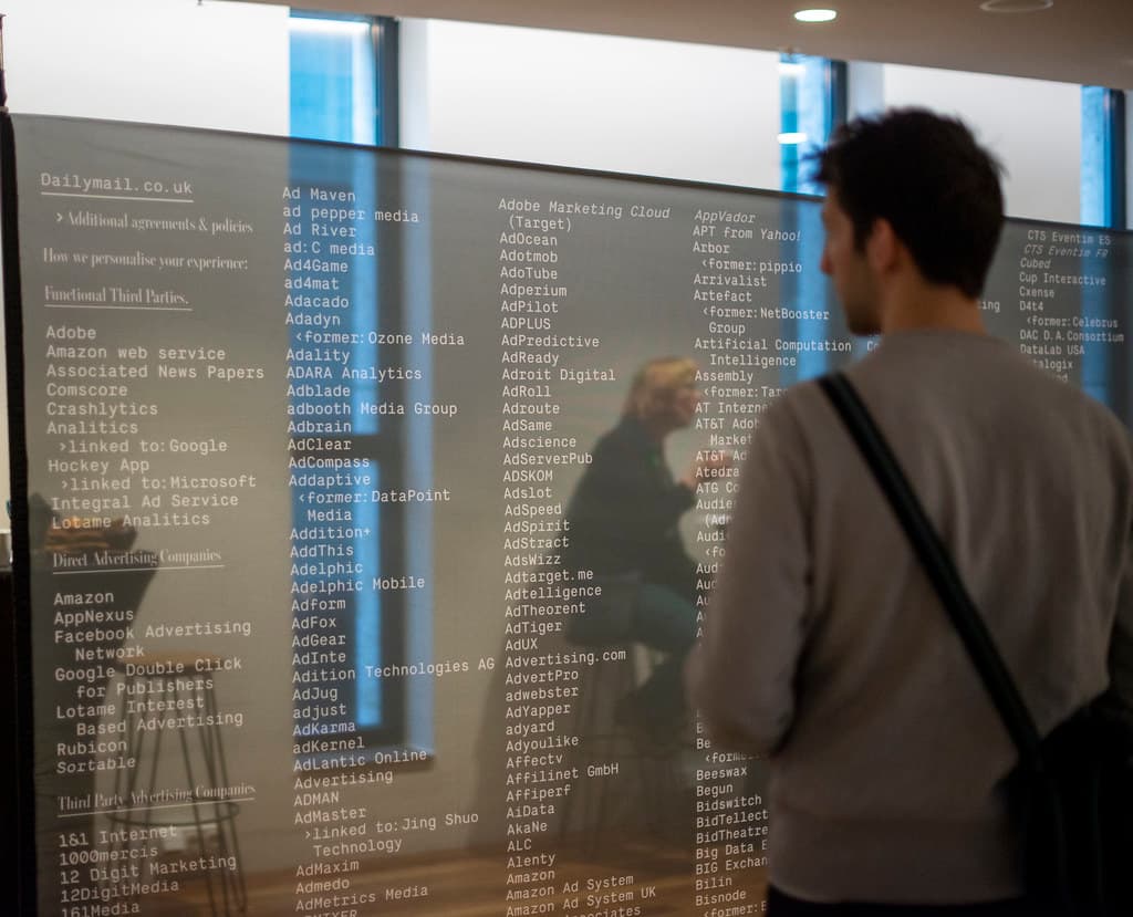 Groot scherm met namen van data vendors op een lijst, een man kijkt ernaar