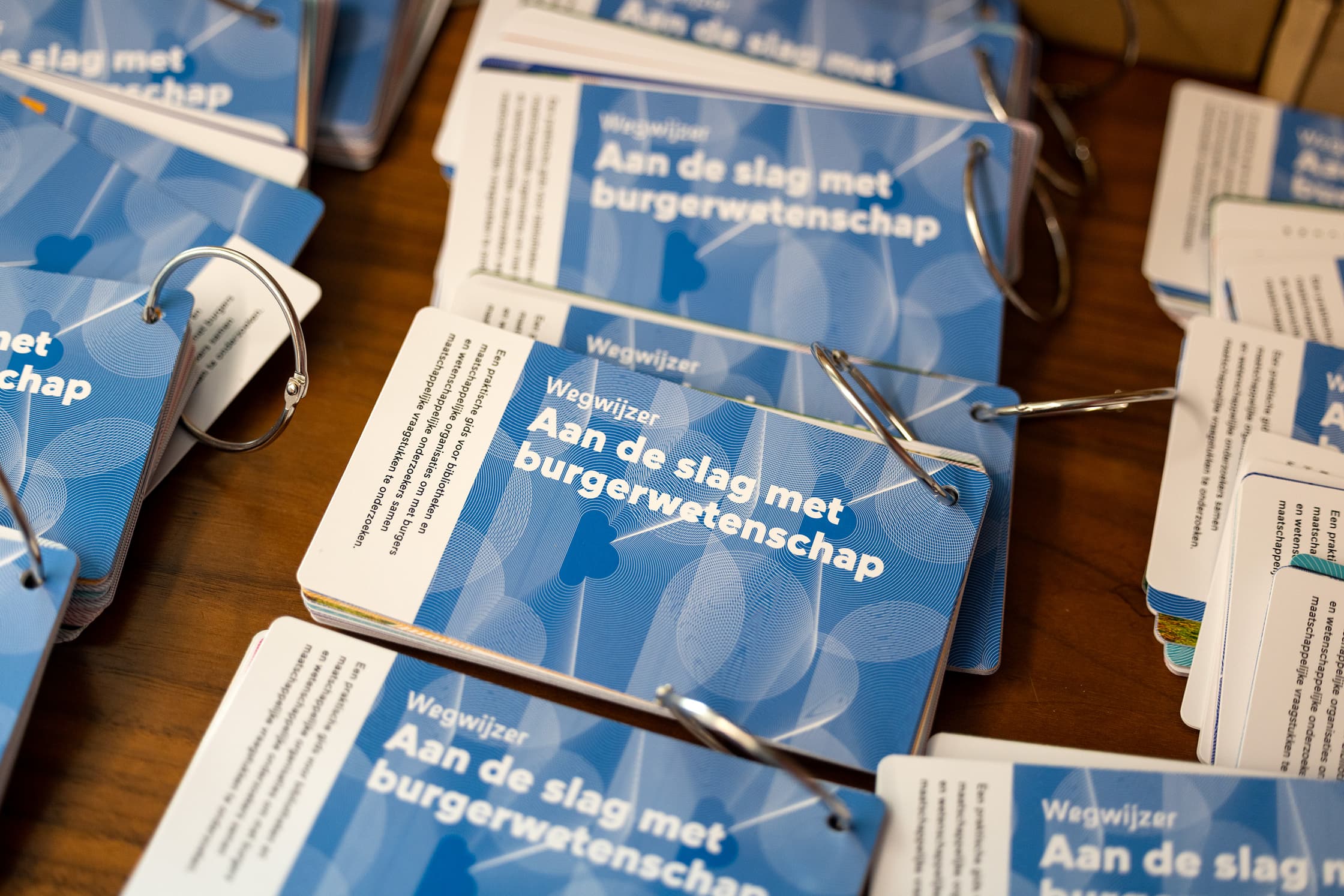 Een aantal exemplaren van de publicatie 'Wegwijzer: aan de slag met burgerwetenschap' liggen op een tafel.