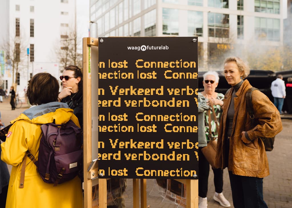 Groot matrix bord met de tekst Connection lost verkeerd verbonden waar mensen omheen staan