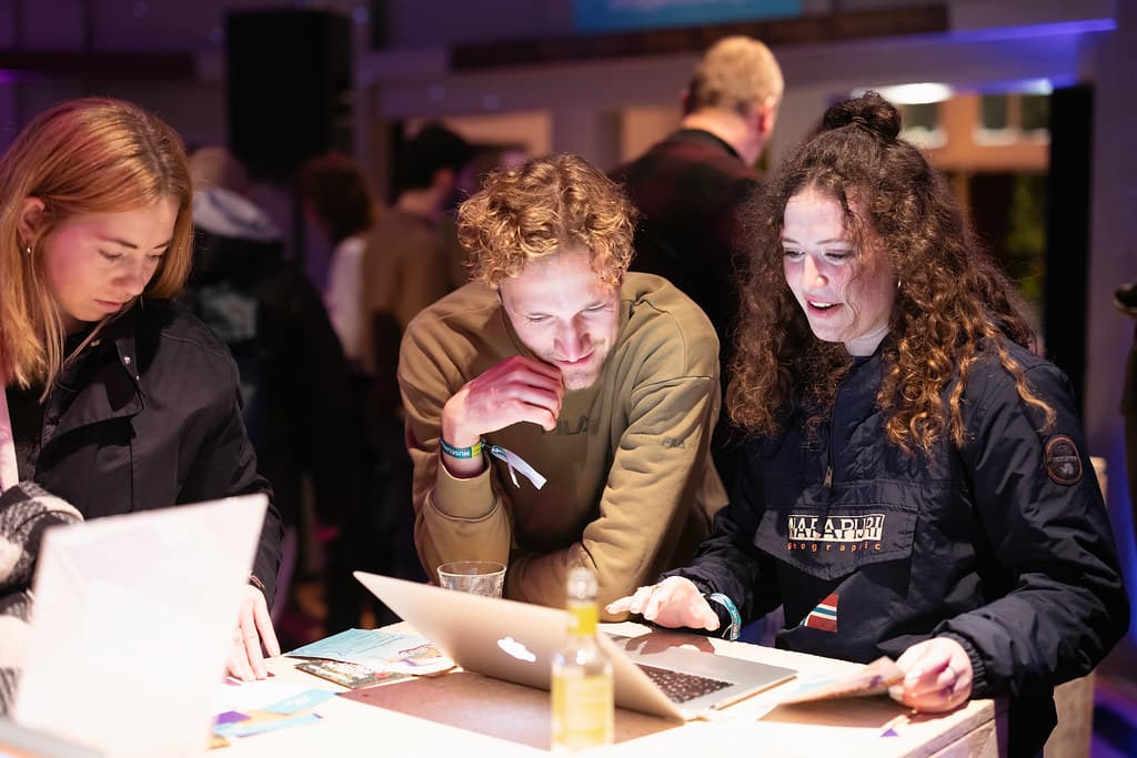 Twee mensen kijken naar een laptop en zijn in gesprek